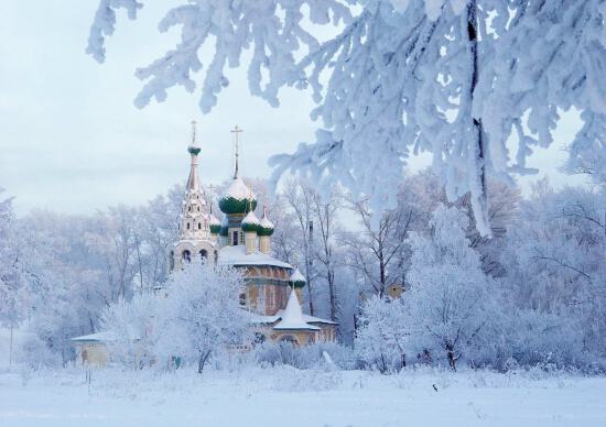 Заснеженный храм среди деревьев