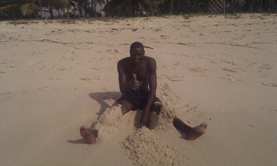 Житель Кении нежится в песке